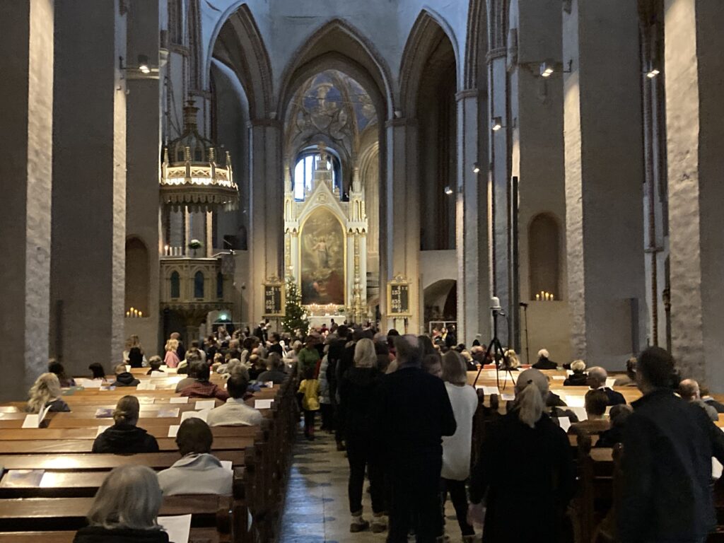 Interirör från Åbo domkyrka med folk i bänkar och mittkorridoren